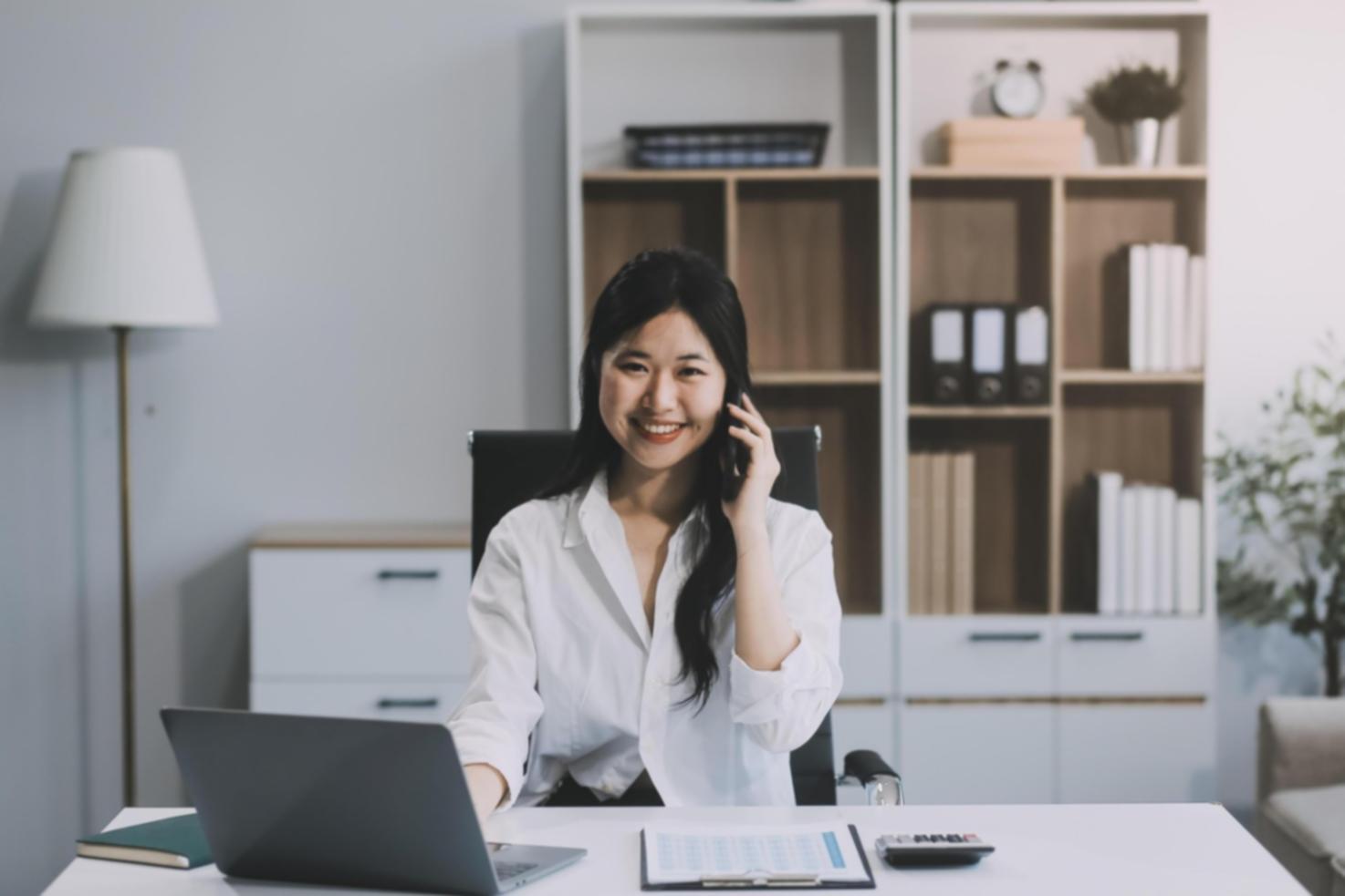 Person reviewing financial documents with calculator and laptop